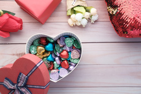 Top view of heart shape gift box with candy on table