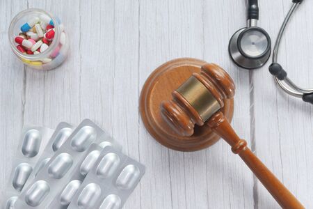 Top view of gavel, stethoscope and pill on whiteの写真素材