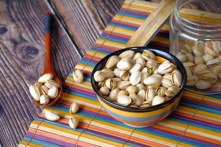 pistachios nut in a jar on table cloth.の写真素材