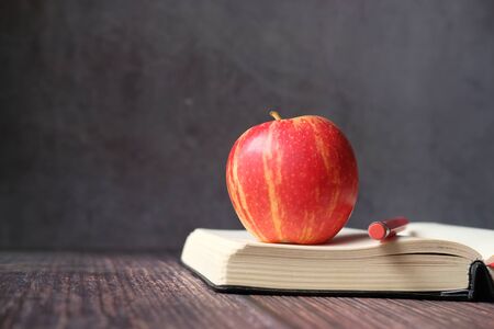 close up of apple on a book on tableの写真素材