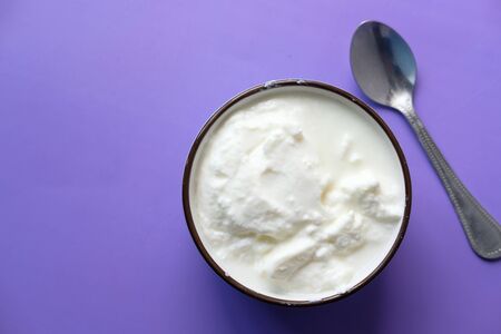 close up of fresh yogurt in a bowl on color background .の写真素材