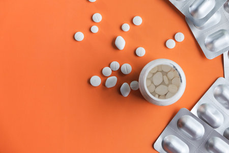 bottle of white pills on orange background