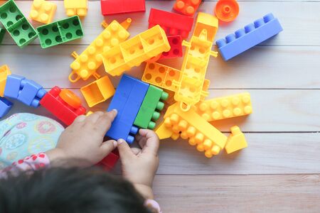 child girl paying with with building blocks on floorの写真素材