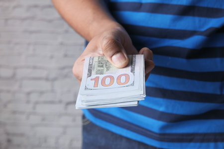 man hand with us 100 dollar cash with copy space