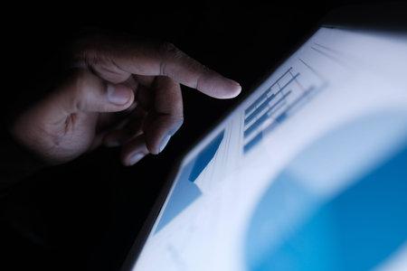Man hand analyzing chart on digital tablet at office desk