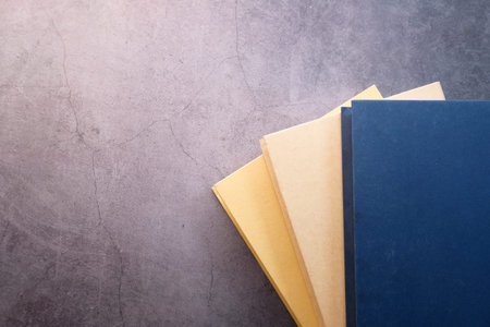 Top view of stack of books on gray background with copy space
