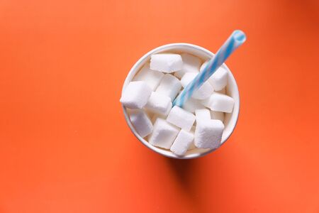 Top view of sugar cube in a plastic container on orange backgroundの写真素材