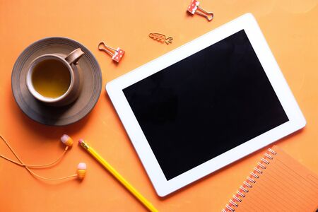 Top view of digital tablet with screen on orange backgroundの写真素材