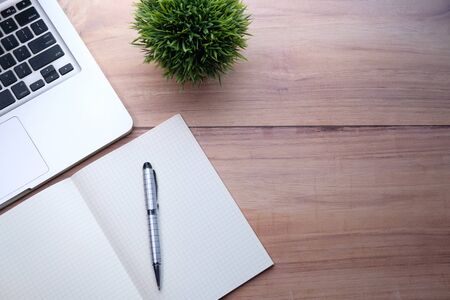 high angle view of open notepad and laptop on tableの写真素材