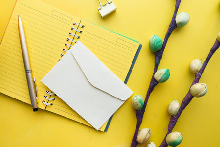 yellow color envelope, notepad and flower on yellow background