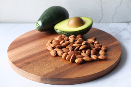 Top view of almond and avocado on chopping board.