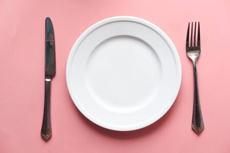 Clean plate and cutlery on pink backgroundの写真素材