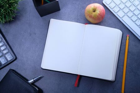 apple , open diary, books and stationary on wooden backgroundの写真素材