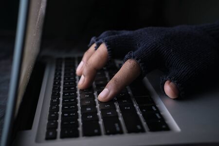 Close up of hacker hand stealing data from laptopの写真素材