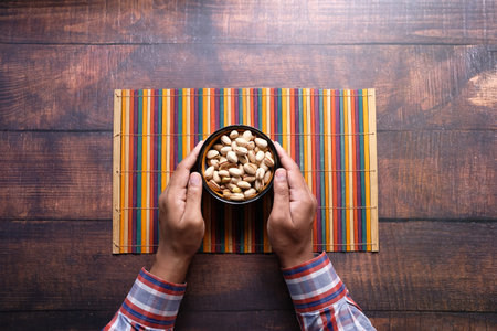 man hand holding a bowl of pistachios nutの写真素材