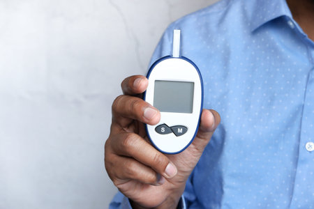 Hand holding blood glucose meters with copy space