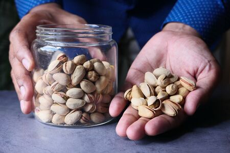 Pistachios nut on palm of man, close upの写真素材