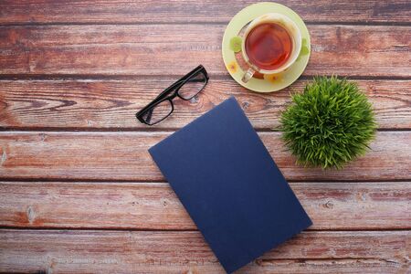 book with empty cover, pen and keyboard on tableの写真素材