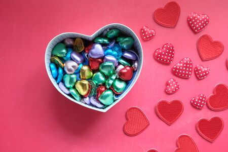 heart shape gift box with candy on red backgroundの写真素材