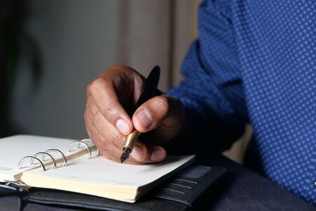 Businessman hand writing with pen on paperの写真素材