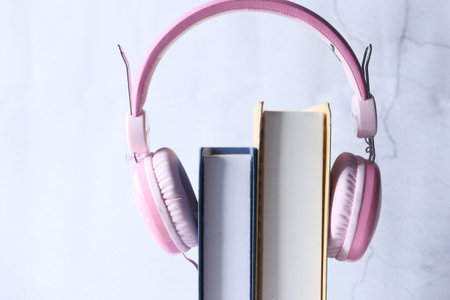 Audio book concept. Headphones and book over wooden table.