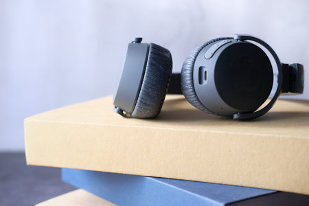 Audio book concept. Headphones and book over wooden table.