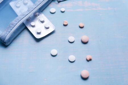 white pills spilling on blue background top downの写真素材