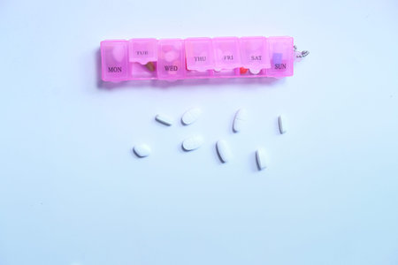 Top view of pill box and pills on white backgroundの写真素材