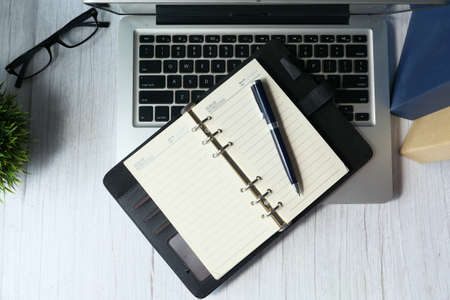 high angle view of notepad on laptop at office deskの写真素材