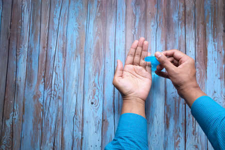 young man using hand sanitizer gel indoorの写真素材