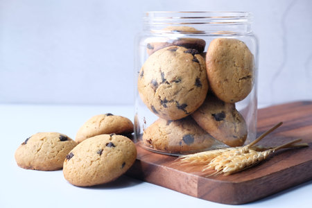 Jar full of chocolate chip cookies on white background