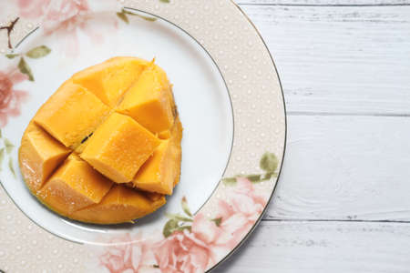 Yellow ripe cut mango on plate, top down.の写真素材