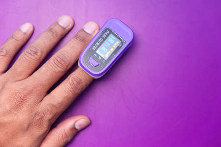 Man finger with pulse oximeter to measure oxygen saturationの写真素材
