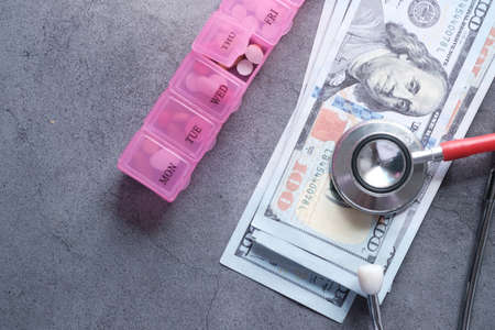 Healthcare cost concept with us dollar, stethoscope and pill boxの写真素材
