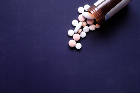 white and pink color pills spilling on blue background