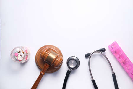 Top view of gavel, stethoscope and pills on white backgroundの写真素材