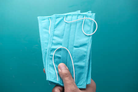 man hand holding protective surgical face mask, close upの写真素材