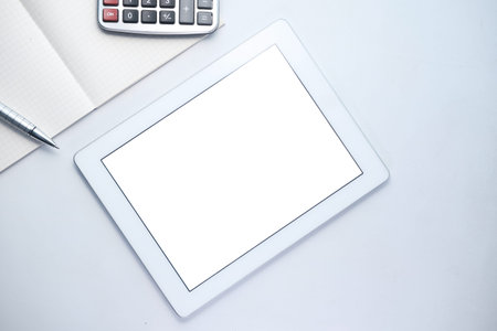 Flat composition of digital tablet and notepad on pink background