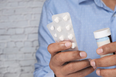 Close up of man hand holding blister pack and contianerの写真素材