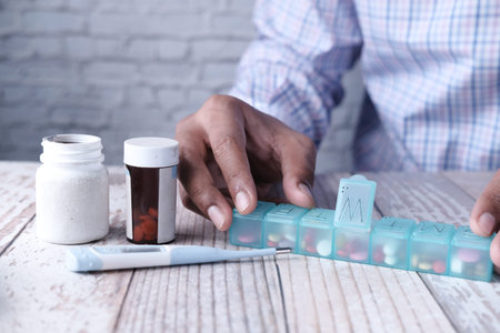 close up of man hand taking medicine from pill box