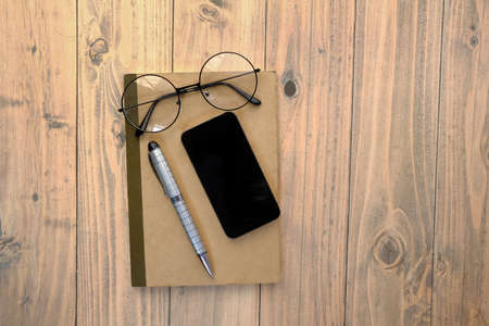 smart phone with empty screen, notepad on wooden tableの写真素材