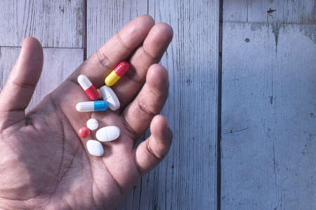 close up of pills and capsule on palm of handの写真素材