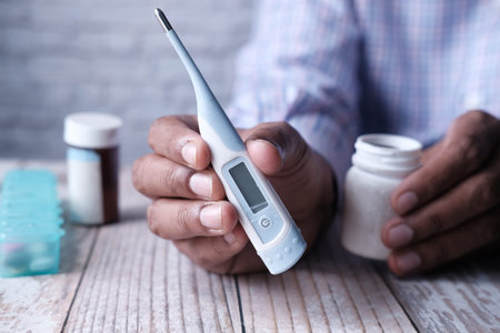 Medical thermometer for measuring body temperature in the hand.