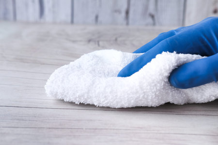 hand holding spray bottle and cleaning table