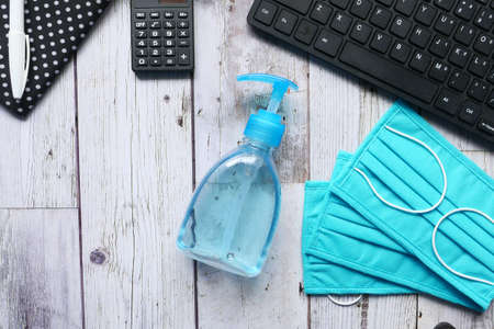 Surgical masks, and hand sanitizer on office deskの写真素材