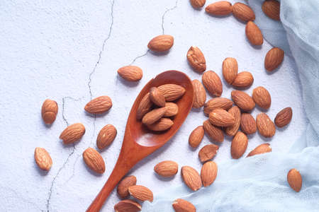 Close up of almond nut on spoon on white backgroundの写真素材