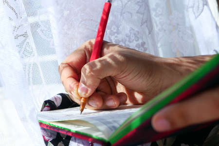 Close up of women hand writing on notepad.の写真素材