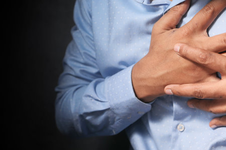 young man suffering heart and holding his chest.