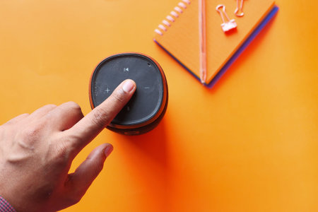 mans hand using smart speaker top down