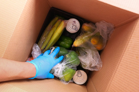Door delivery of goods. Order picker packing foods in a cardboard boxes.